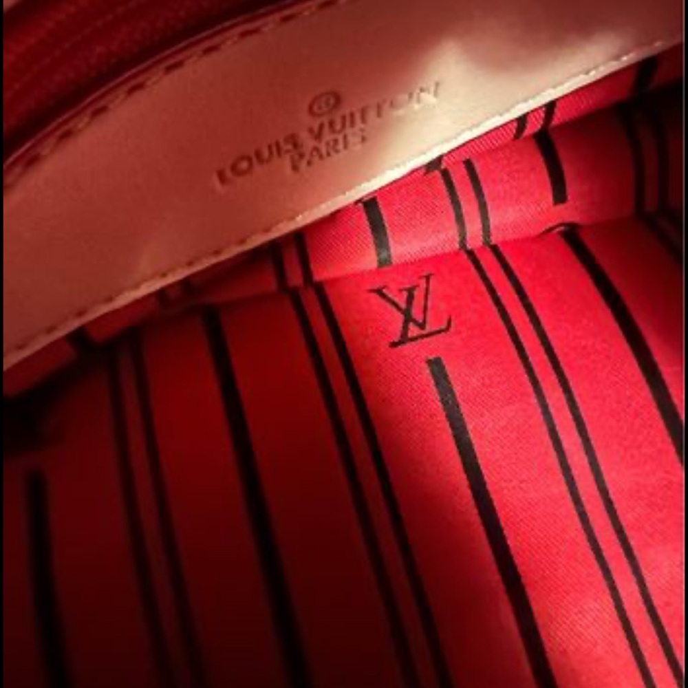 Louie Vuitton duffel bag has tags red inside